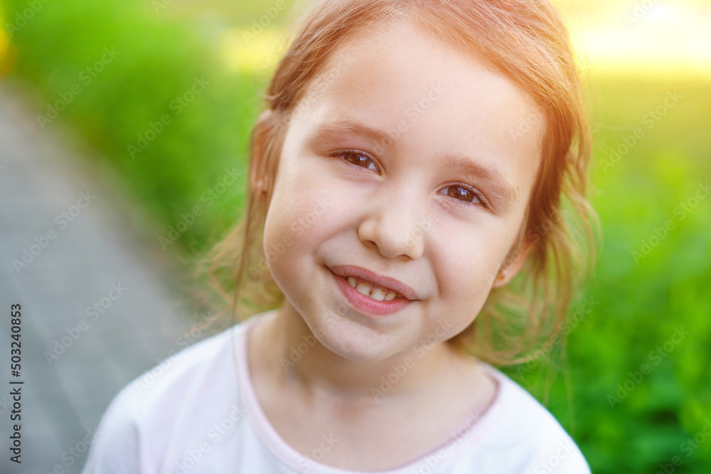 Happy little caucasian baby girls showing front teeth with big smile and healthy laughing on nature background on summer day. Happy funny smiling face of young adorable lovely woman kid. Happy little caucasian baby girls showing front teeth with big smile and healthy laughing on nature background on summer day. Happy funny smiling face of young adorable lovely woman kid.