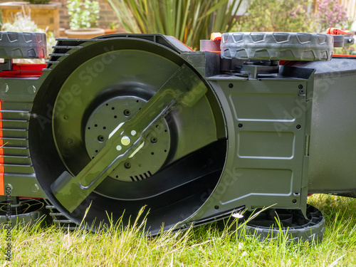 underside of a cordless lithium ion battery powered lawn mower exposing the rotary blade photo