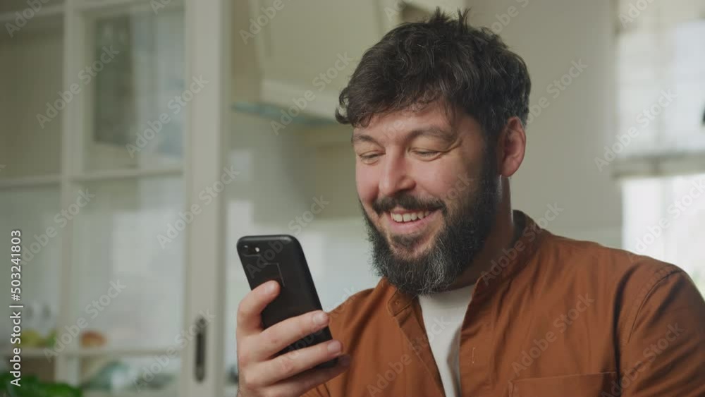 Young adult caucasian man browsing on his smartphone indoors Young adult caucasian man browsing on his smartphone indoors