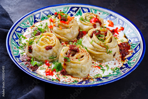 Traditional Afghan ay khanom steamed with mincemeat, paprika and yogurt as close-up on a classic plate photo