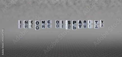 income disparity word or concept represented by black and white letter cubes on a grey horizon background stretching to infinity