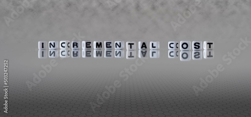 incremental cost word or concept represented by black and white letter cubes on a grey horizon background stretching to infinity