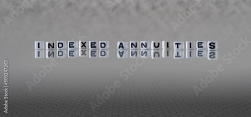 indexed annuities word or concept represented by black and white letter cubes on a grey horizon background stretching to infinity