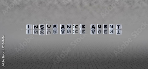 insurance agent word or concept represented by black and white letter cubes on a grey horizon background stretching to infinity