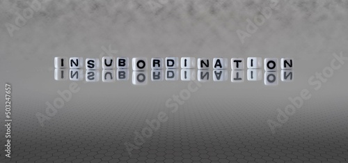 insubordination word or concept represented by black and white letter cubes on a grey horizon background stretching to infinity