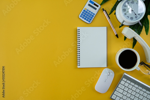 Office desk table with a laptop, notebook, and coffee cup, as well as other office supplies and equipment. The concept of business and finance. Flat lay with blank copy space at a workplace.