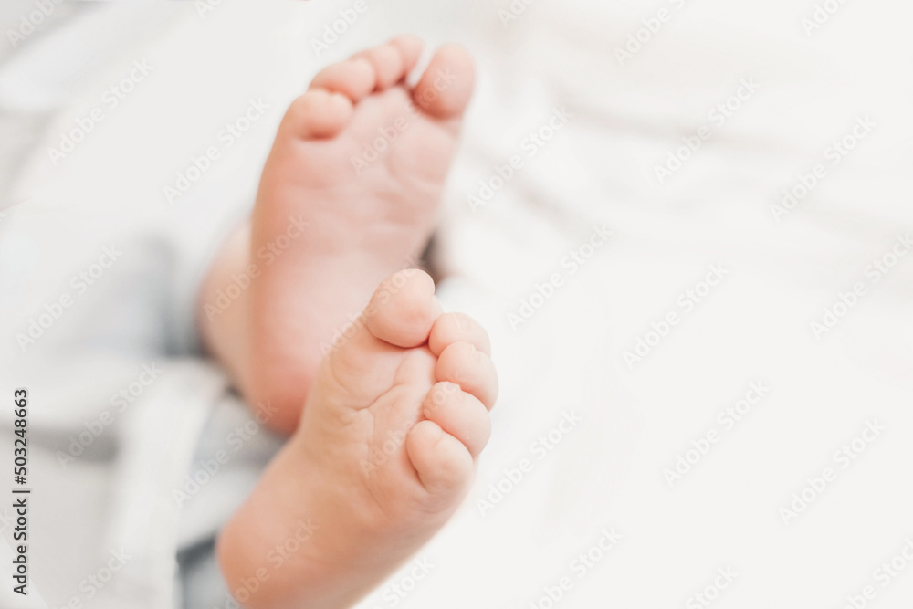 two baby feet on the background of white bed linen. copy space. Ukrainian newborn. baby's little toes. top view two baby feet on the background of white bed linen. copy space. Ukrainian newborn. baby's little toes. top view