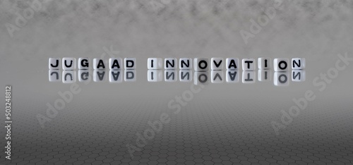 jugaad innovation word or concept represented by black and white letter cubes on a grey horizon background stretching to infinity photo