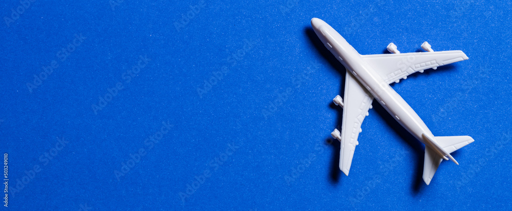 A miniature airplane isolated on blue background, Travel or traffic background, Nobody A miniature airplane isolated on blue background, Travel or traffic background, Nobody