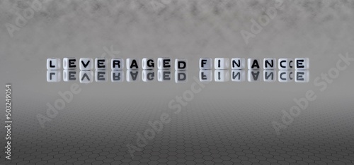leveraged finance word or concept represented by black and white letter cubes on a grey horizon background stretching to infinity