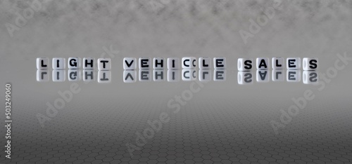 light vehicle sales word or concept represented by black and white letter cubes on a grey horizon background stretching to infinity