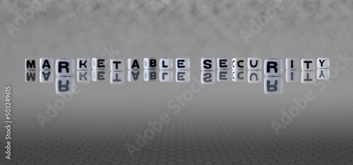 marketable security word or concept represented by black and white letter cubes on a grey horizon background stretching to infinity photo