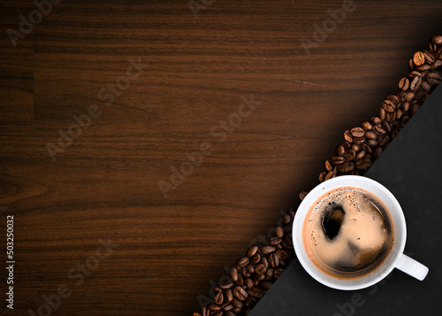 Cup of coffee with coffee beans on table