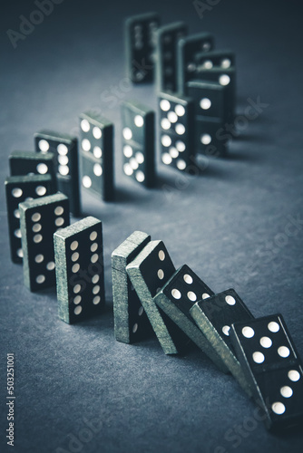 Black dominoes chain on dark table background photo