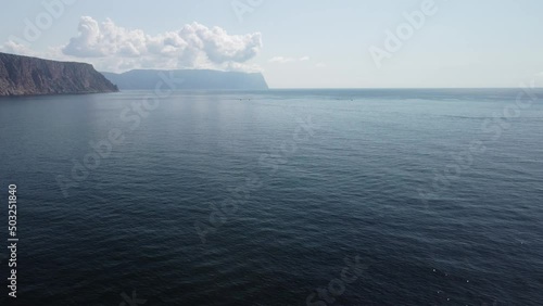 Wallpaper Mural Aerial view from above on calm azure sea and volcanic rocky shores. Small waves on water surface in motion blur. Nature summer ocean sea beach background. Nobody. Holiday, vacation and travel concept Torontodigital.ca