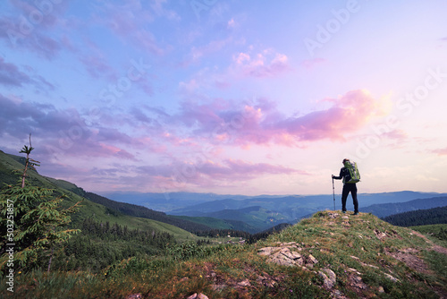 Active lifestyle. Traveling, hiking and trekking concept. Young woman with backpack in the Carpathian mountains on sunset.