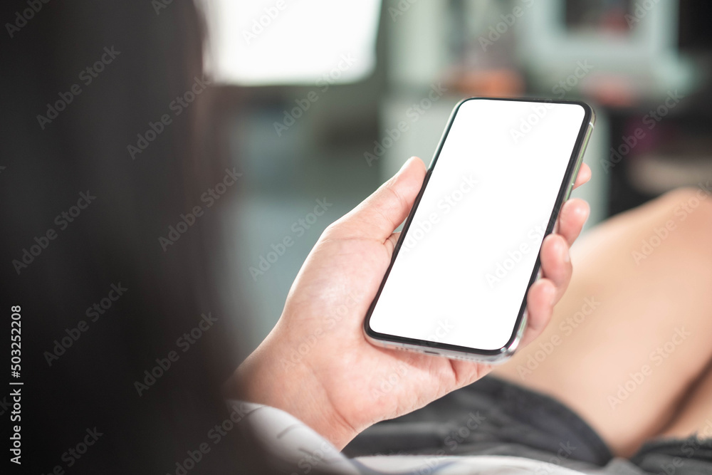 mockup phone in woman hand showing white screen at home, taken from the rear view,minimal concept