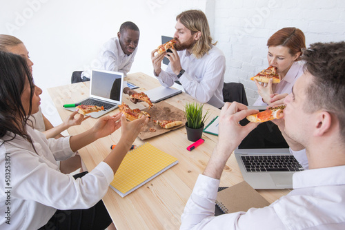 Diverse team workers eating pizza