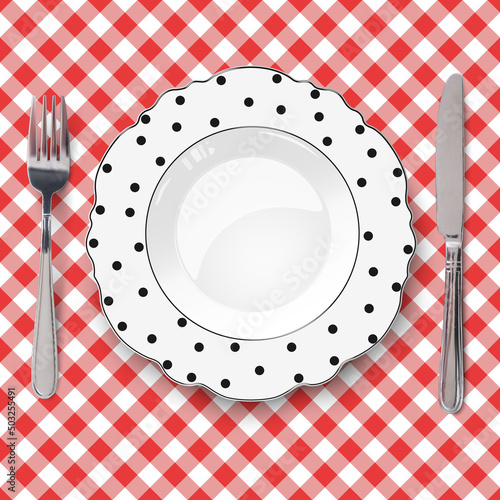 White vector plate with figured edges and polka dot pattern placed on red check classic seamless tablecloth. Closeup view from above.
