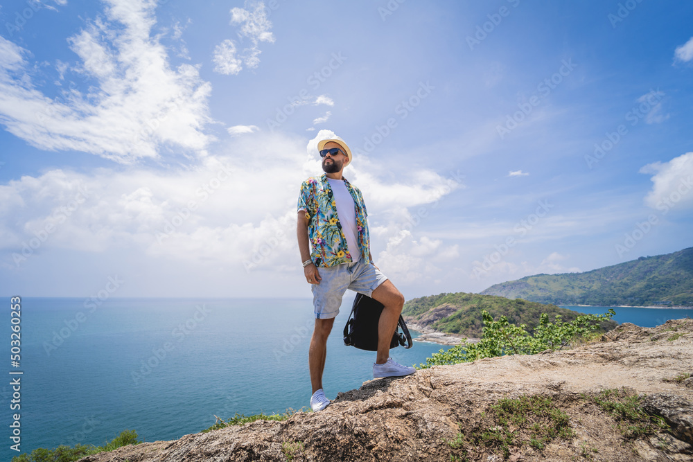 Young traveler man at summer holiday vacation with beautiful mountains and seascapes at background Young traveler man at summer holiday vacation with beautiful mountains and seascapes at background