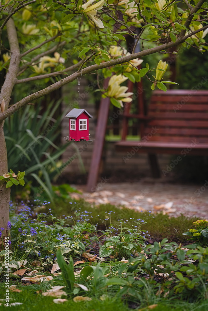 Decorative feeder and wooden bench in the garden Decorative feeder and wooden bench in the garden