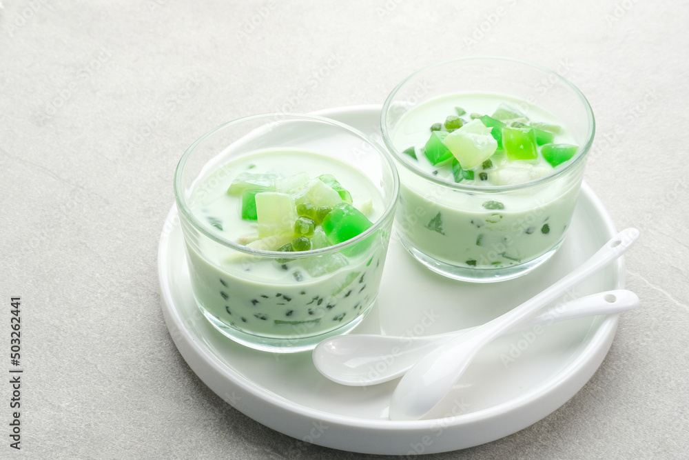 Buko Pandan, a dessert from Philippines, made from jelly, young coconut, evaporated milk, sweetened condensed milk, and ice. Served on glass with cheese topping. Selective focus.
Buko Pandan, a dessert from Philippines, made from jelly, young coconut, evaporated milk, sweetened condensed milk, and ice. Served on glass with cheese topping. Selective focus.