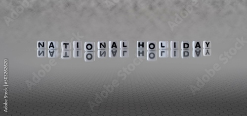 national holiday word or concept represented by black and white letter cubes on a grey horizon background stretching to infinity