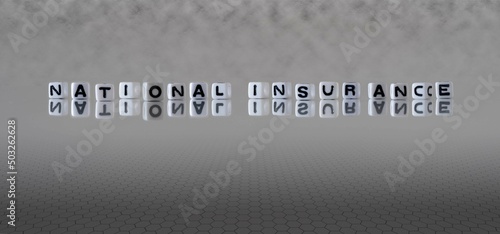 national insurance word or concept represented by black and white letter cubes on a grey horizon background stretching to infinity