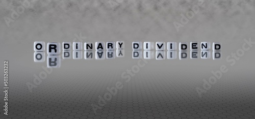ordinary dividend word or concept represented by black and white letter cubes on a grey horizon background stretching to infinity