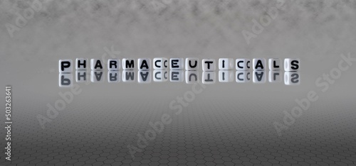 pharmaceuticals word or concept represented by black and white letter cubes on a grey horizon background stretching to infinity