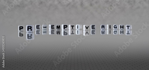 pre emptive right word or concept represented by black and white letter cubes on a grey horizon background stretching to infinity photo