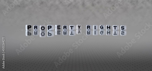 property rights word or concept represented by black and white letter cubes on a grey horizon background stretching to infinity
