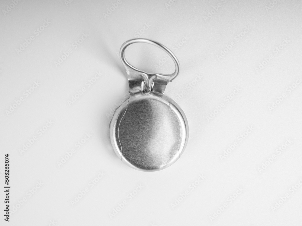 Close-up used silver ring pull bottle cap of glass bottle with blank space on the cap isolated on white background, top view. Close-up used silver ring pull bottle cap of glass bottle with blank space on the cap isolated on white background, top view.