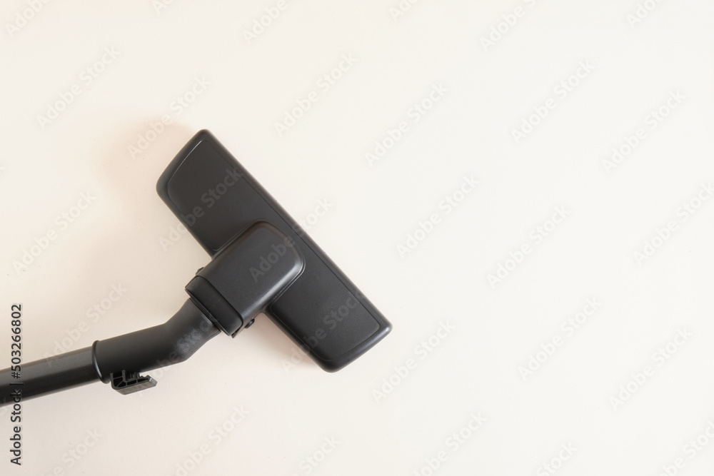 Head of modern vacuum cleaner on beige background. Close up. Head of modern vacuum cleaner on beige background. Close up.