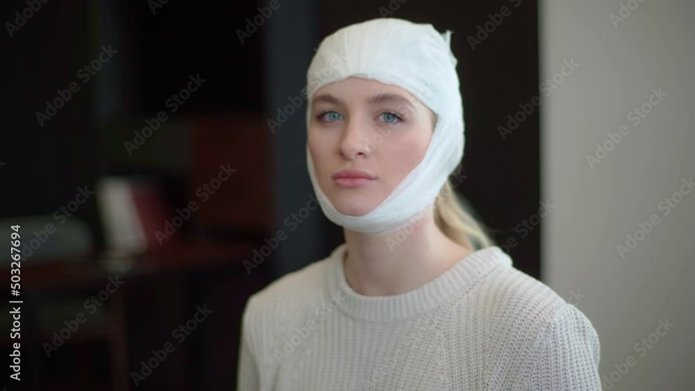 A young attractive woman with a postoperative bandage looks straight into the camera. A young attractive woman with a postoperative bandage looks straight into the camera.