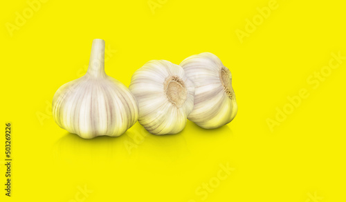 raw garlic isolated on yellow background