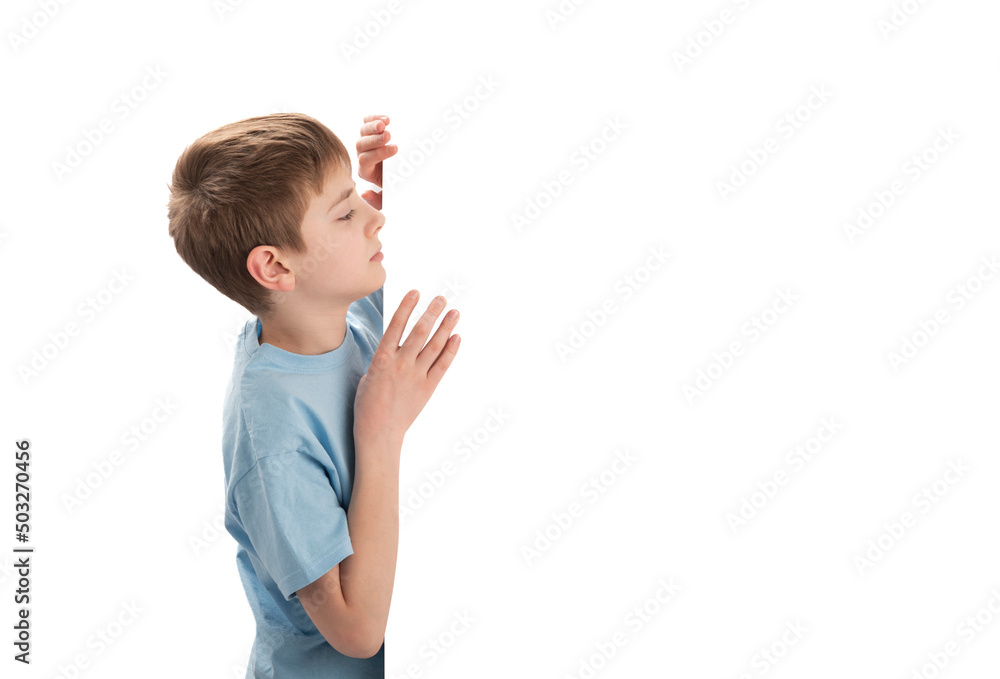 Young Caucasian schoolboy peeking out from blank copy space. Boy with an empty poster. Copy space. Young Caucasian schoolboy peeking out from blank copy space. Boy with an empty poster. Copy space.