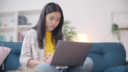 Asian woman getting virus on laptop, uncertified software, malicious program photo