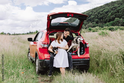 Family with animals in nature on the background of his car