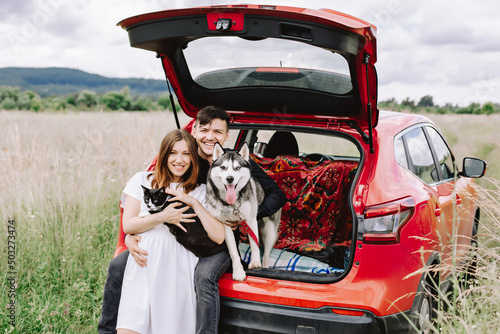 Family with animals in nature on the background of his car