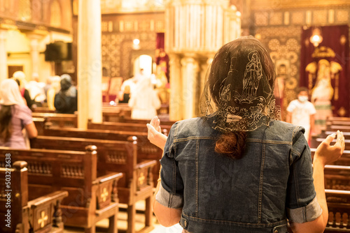 A lady praying and professing her religion inside a Church in Cairo. Photograph taken in the Coptic neighborhood, Cairo, Egypt. photo