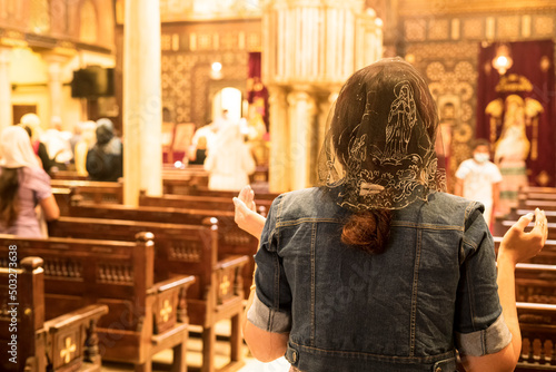 A lady praying and professing her religion inside a Church in Cairo. Photograph taken in the Coptic neighborhood, Cairo, Egypt.
