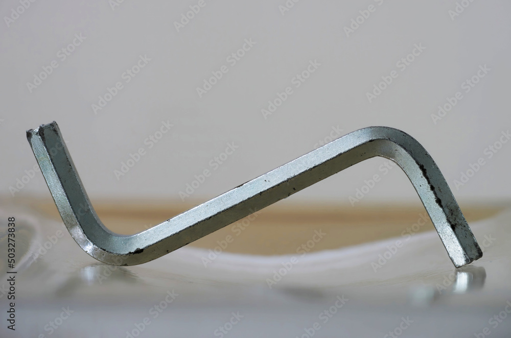 Close-up photo of a used Allen key (Allen wrench) on a white background Close-up photo of a used Allen key (Allen wrench) on a white background