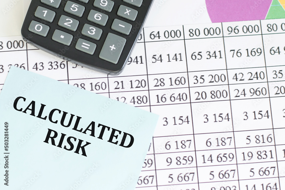 Business concept. Calculated risk text on a holzboy card on the background of reports and charts on the table Business concept. Calculated risk text on a holzboy card on the background of reports and charts on the table