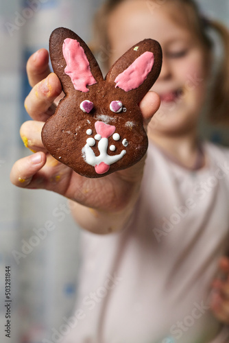 Little beautiful girl shows gingerbread, which she made herself.