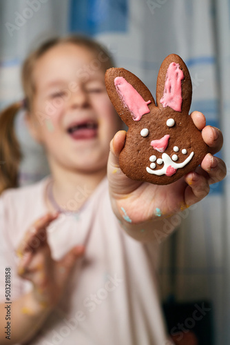 Little beautiful girl shows gingerbread, which she made herself.