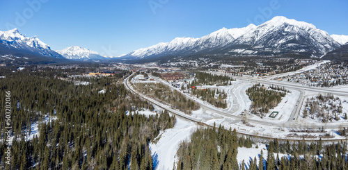 Aerial panorama view of Town of Canmore and Canadian Rockies mountain range in winter. Grotto mountain. Alberta, Canada.