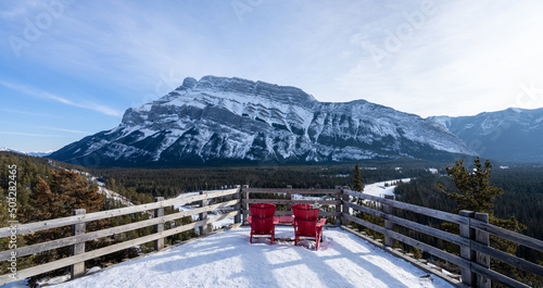Banff National Park beautiful landscape. Red chair look over Mount Rundle in snowy winter sunny day. Hoodoos Viewpoint, Canadian Rockies. photo