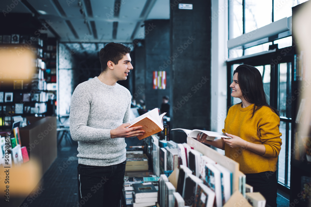 Cheerful friends with books chatting in bookshop