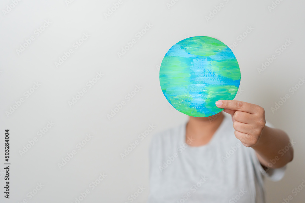 Woman with planet Earth hidden her face. Concept of Earth day, environmental conservation. Woman holding earth paper cut showing Love and care of the world. Woman with planet Earth hidden her face. Concept of Earth day, environmental conservation. Woman holding earth paper cut showing Love and care of the world.